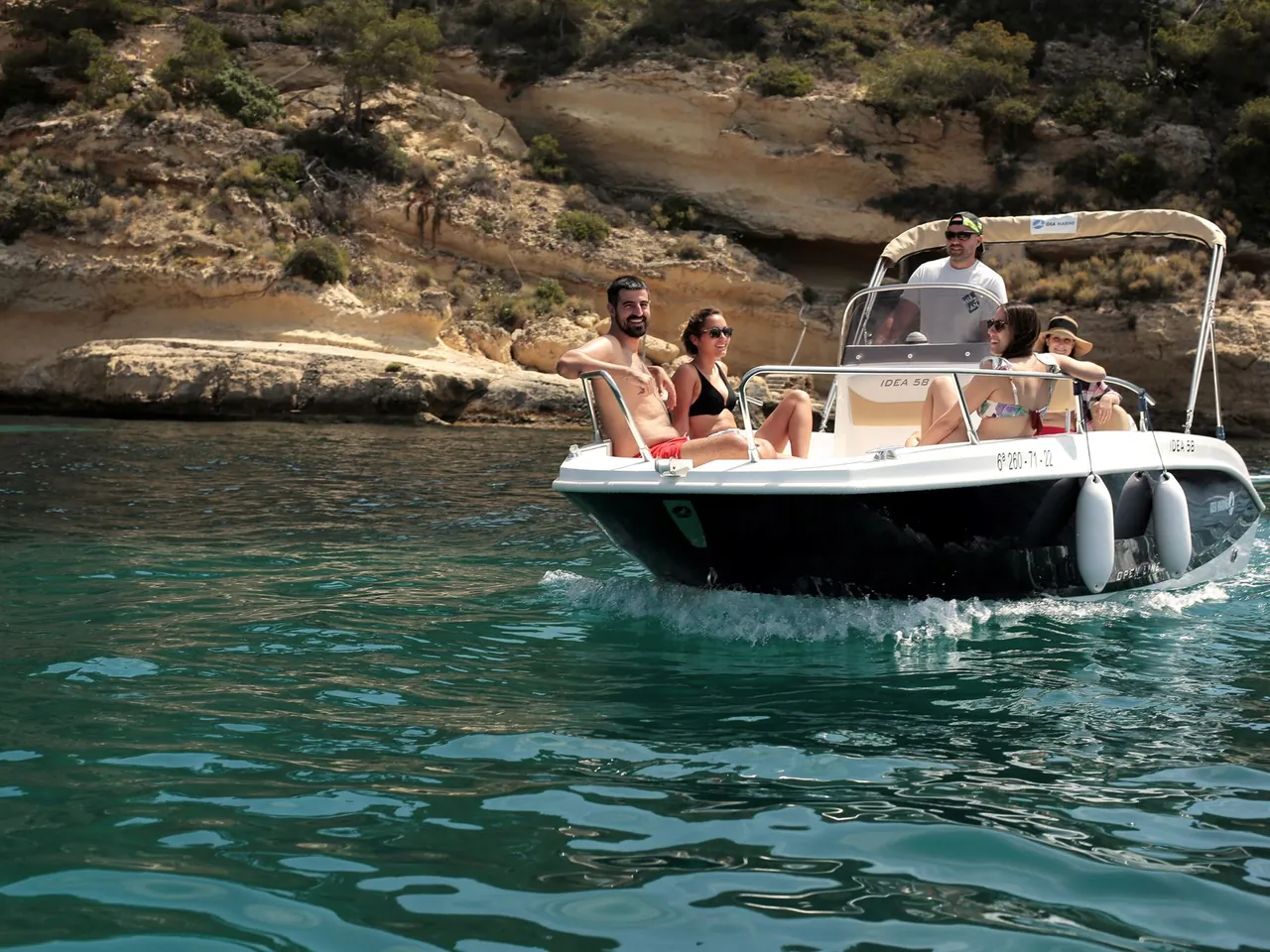 Grupo a bordo fondeado en una cala turquesa de la Bahía de Palma a mediodía